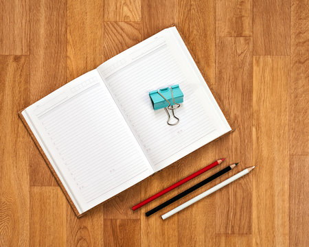 Blank notepad with office supplies on wooden table.