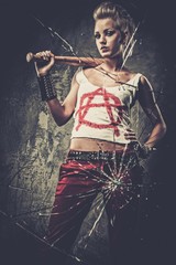 Punk girl behind broken glass with a baseball bat