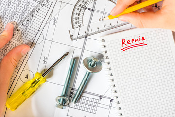 Draw a plan of home renovation, hand holding a ruler and pencil