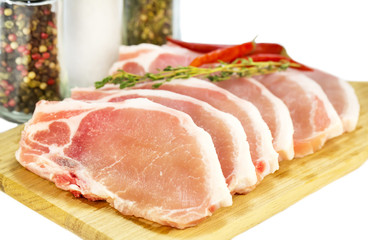 raw pork steaks on a cutting board