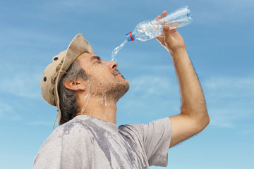 Man refreshing himself with water, outdoor shot.