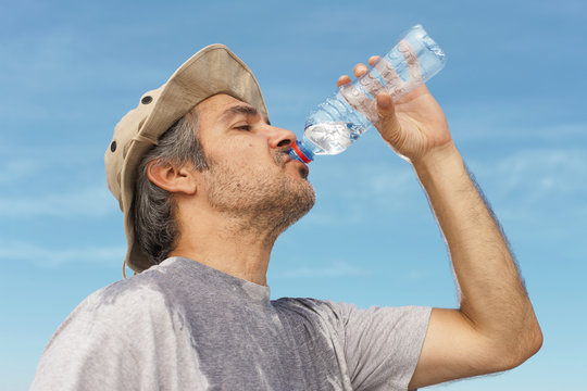 Man drinking water, outdoor shot.
