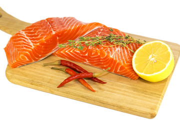 raw salmon steak with lemon and spices on a cutting board