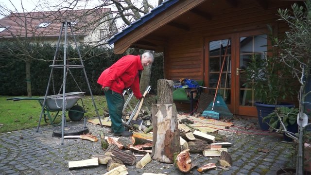 Mann zers&auml;gt Holz f&uuml;r Brennholz