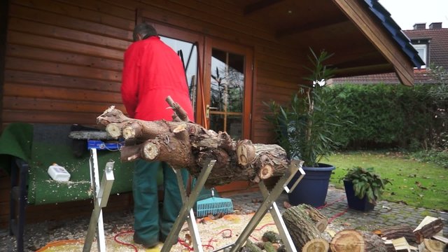 Mann zers&auml;gt Holz f&uuml;r Brennholz