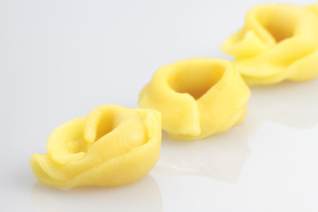 Three tortellini on white background.