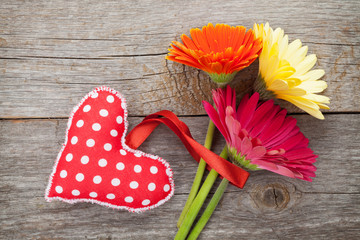 Colorful gerbera flowers and Valentine's day heart toy