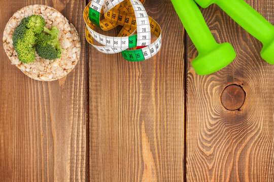Dumbells, tape measure and healthy food. Fitness and health