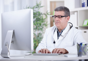 serious  modern senior doctor with glasses in the office