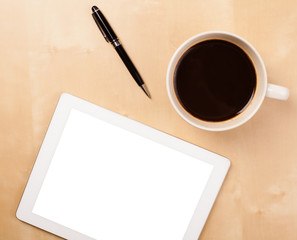 Tablet pc with empty space and a cup of coffee on a desk