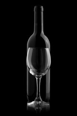 Elegant wine bottle and wine glass in a black background