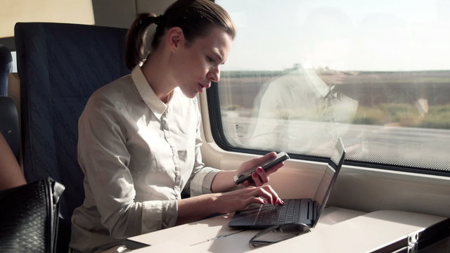Busy businesswoman working with smartphone and laptop computer o
