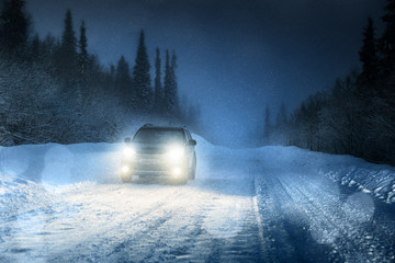 Naklejka premium Car lights in winter forest