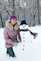 Beautiful girl near a snowman