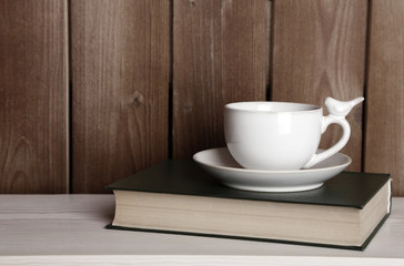 Old books and cup of coffee on table