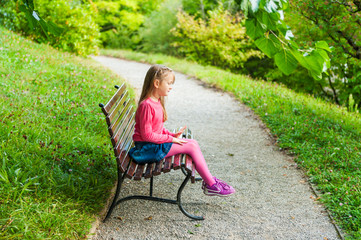 Naklejka na ściany i meble Cute little girl playing in a park