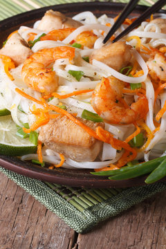 Rice noodles with seafood and chicken closeup. Vertical