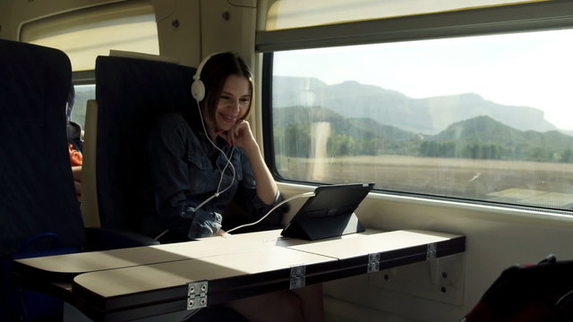 Young Woman In Headphones Watching Funny Movie On Tablet During 