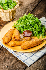Corn dog with fresh arugula salad and hot dip