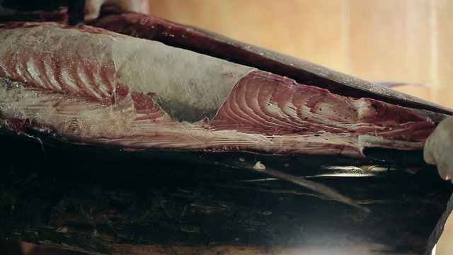 Fish production guys undress a body of big swordfish
