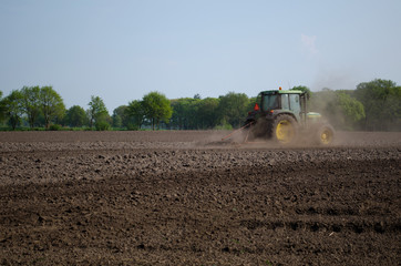 Fototapeta premium Tractor in plowed field