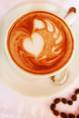 Cup of coffee with cute drawing in cafe