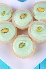 Tartlets with greens and sauce on plate close-up