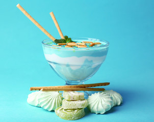 Mint milk dessert in glass bowl on color background