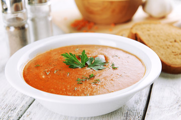 Delicious lentil cream-soup on table close-up