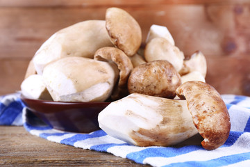 Wild mushrooms on plate on wooden background