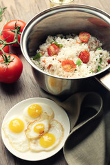 Tasty rice in pan on wooden table