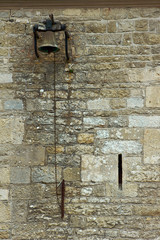The bell on the wall of a medieval monastery in France.