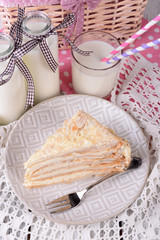 Napoleon cake with milk on table close-up