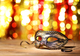 Beautiful carnival mask on table on bright background