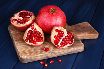 Juicy ripe pomegranates on blue wooden table