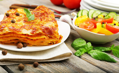 Portion of tasty lasagna on wooden table