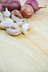 garlic cloves and shallot  on wood cutting board