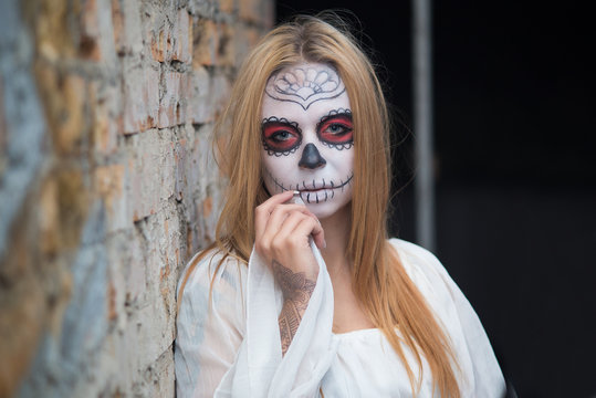 Portrait of a young girl in the image of Santa Muerte