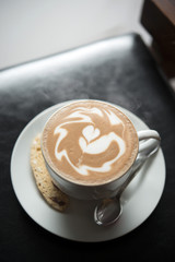 Hot coffee  with latte art on black table