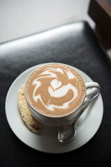 Hot coffee  with latte art on black table