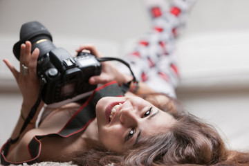 pretty girl with a photo camera in a living room