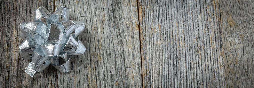 Silver Holiday Bow On Rustic Wood Background