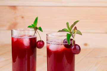 Cherry smoothie on the wooden background.