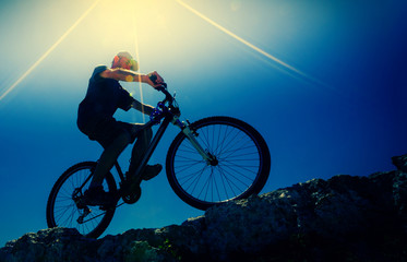 Fototapeta na wymiar male cyclist on a mountain bike, backlit