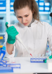 Female laboratory assistant with a pipette in a scientific labor