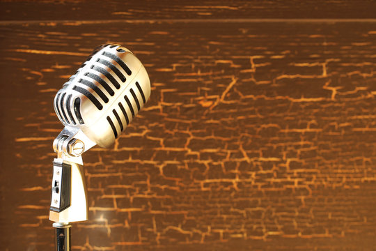 Silver vintage microphone in the studio on wood background