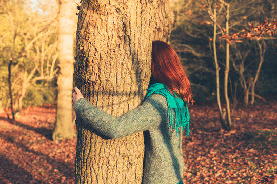 Woman hugging tree at sunset