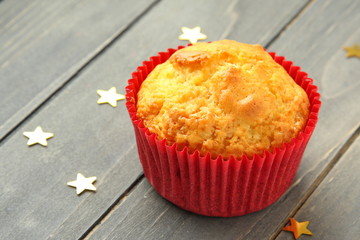 Muffins in red cups op wooden table