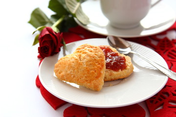 Heart shaped scones with strawberry jam and a cup of tea