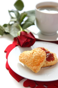 Heart shaped scones with strawberry jam and a cup of tea